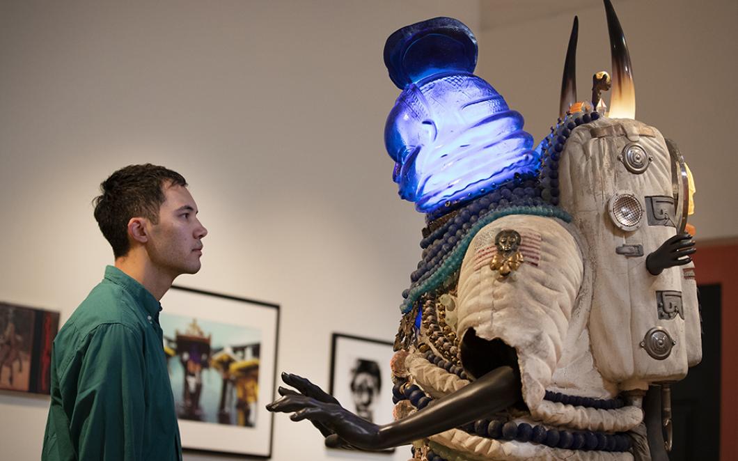 A visitor interacts with Zak Ové’s 'Umbilical Progenitor'