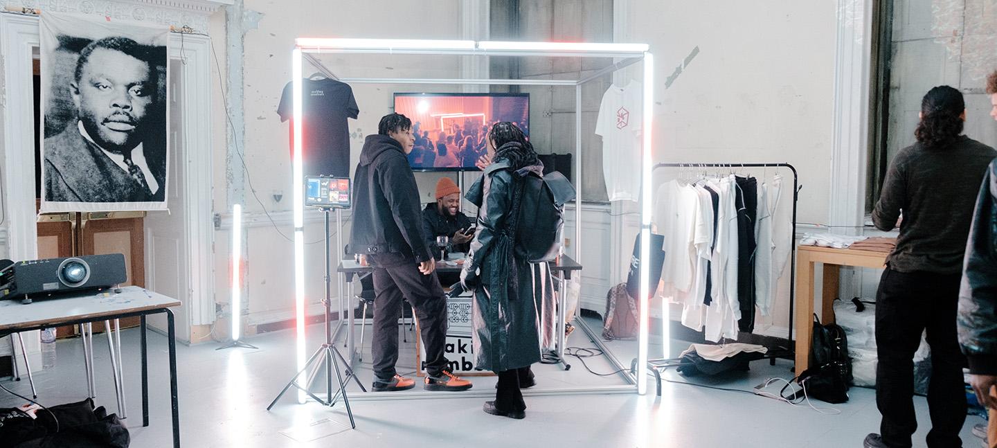 A BBI member displays their products and work, whilst talking to someone animatedly.