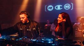 Rinse FM founder Geeneus on the decks with a guest to his right and a crowded audience in the background at a 30th anniversary event