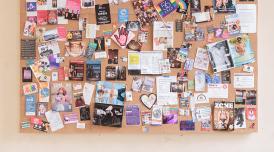 Installation view of UK Gay Bar Directory. The image shows an artwork presenting flyers and flags from different gay bars.